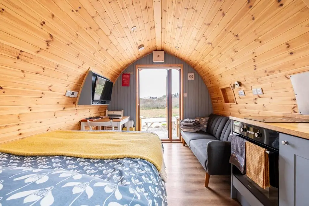 a bedroom with a bed and a couch in a room at Luxury Pod 3 in Bonar Bridge