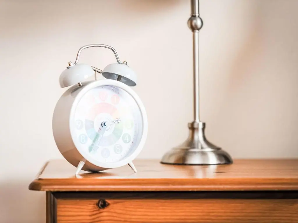 a silver alarm clock sitting on top of a wooden table at Holiday Home Farmburn by Interhome in Invermoriston