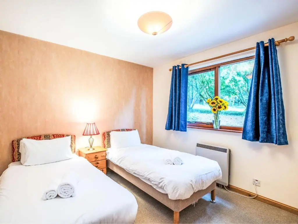 two beds in a room with a window at Holiday Home Farmburn by Interhome in Invermoriston