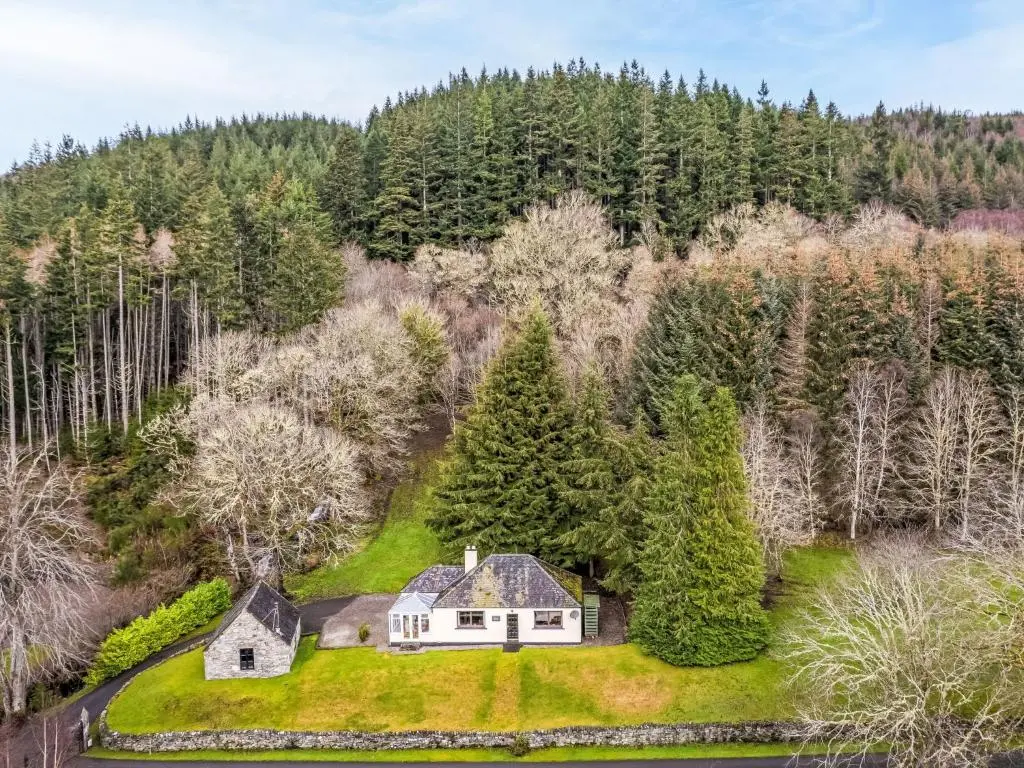 an estate in the woods with a white house on a green lawn at Holiday Home Farmburn by Interhome in Invermoriston
