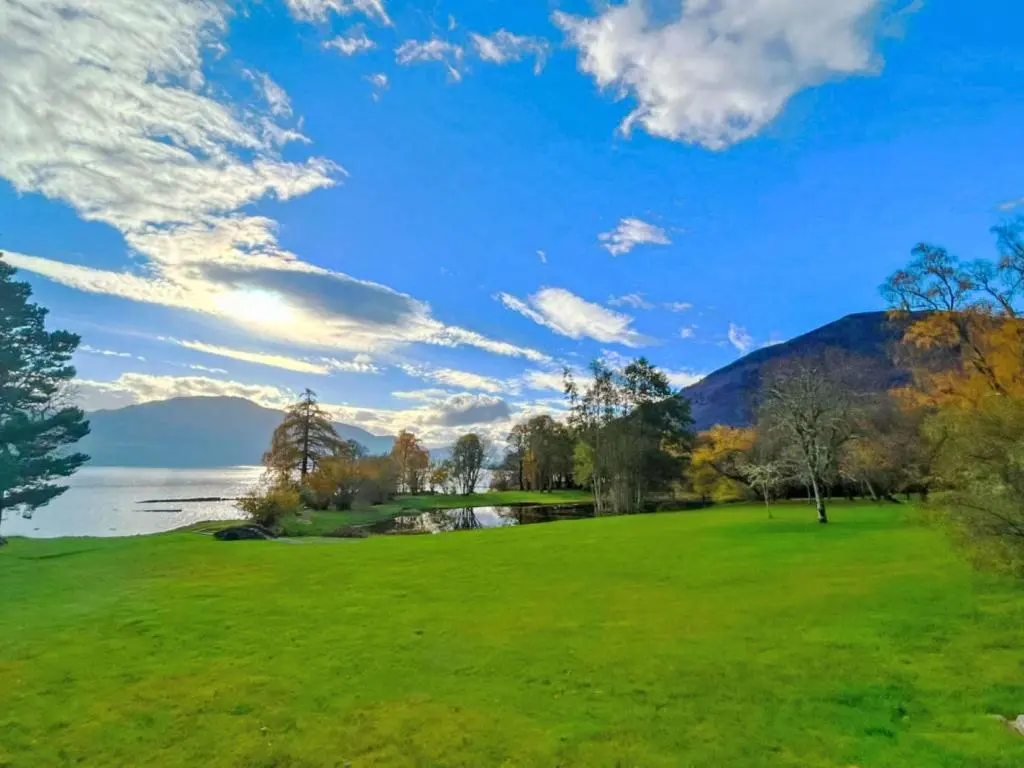 a green field next to a body of water at Holiday Home Farmburn by Interhome in Invermoriston