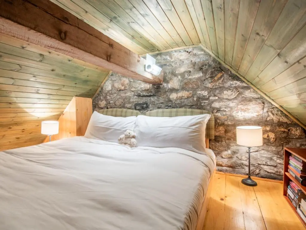 a bedroom with a bed with a teddy bear on it at Holiday Home Farmburn Bothy by Interhome in Invermoriston