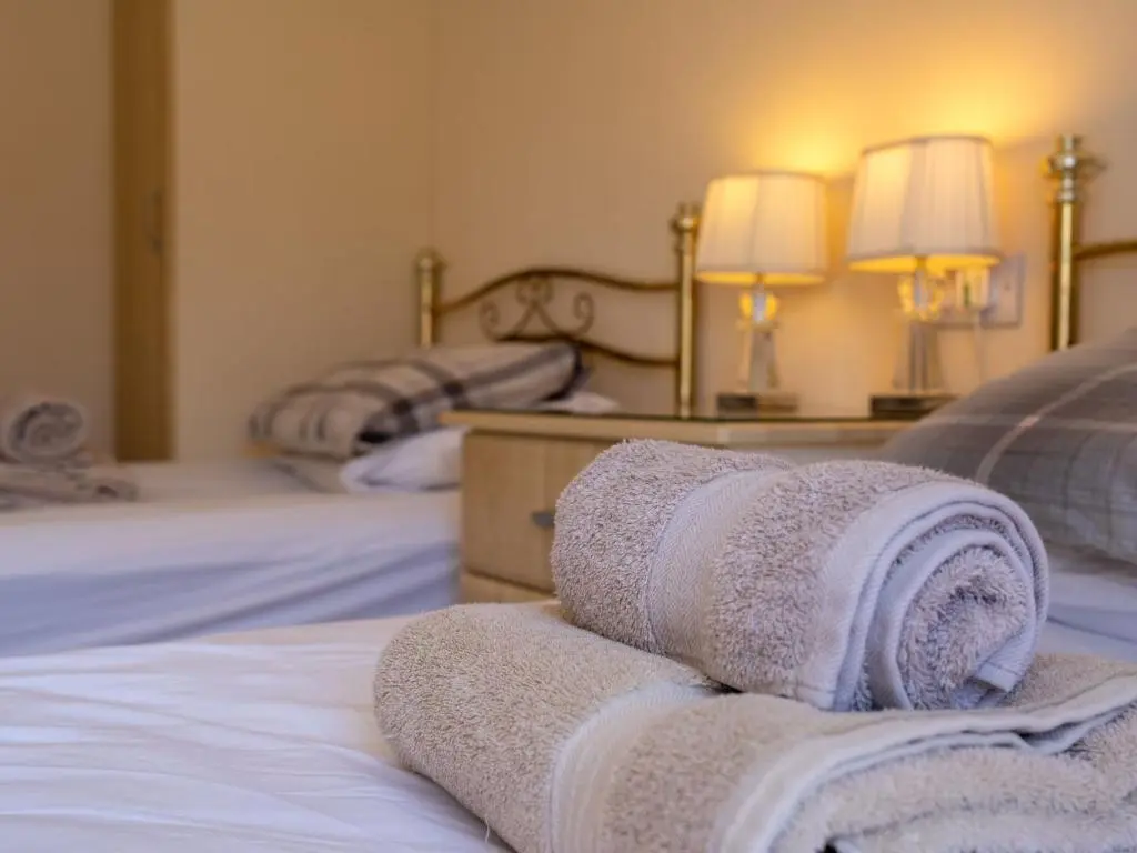 a bedroom with two beds with towels on them at Chalet Lodge 5 by Interhome in Boat of Garten