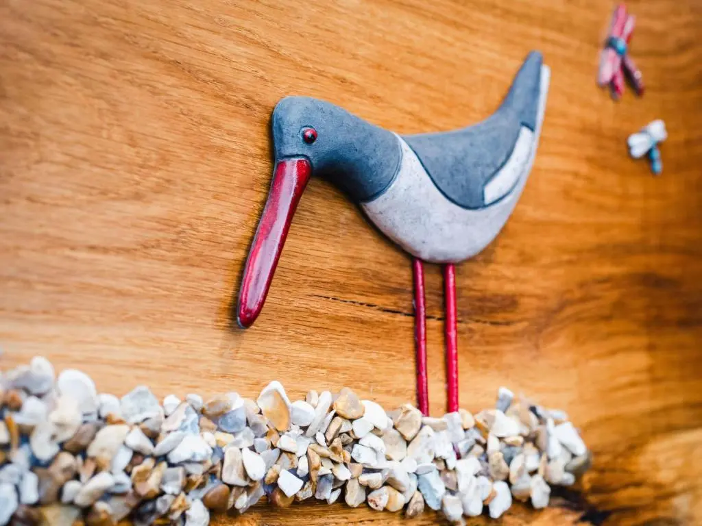 a plastic bird on a table with a pile of peanuts at Chalet Oystercatcher by Interhome in Spean Bridge