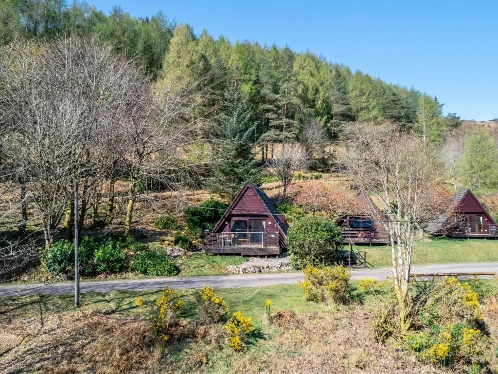 a house in the mountains with a road and trees at Chalet Oystercatcher by Interhome in Spean Bridge