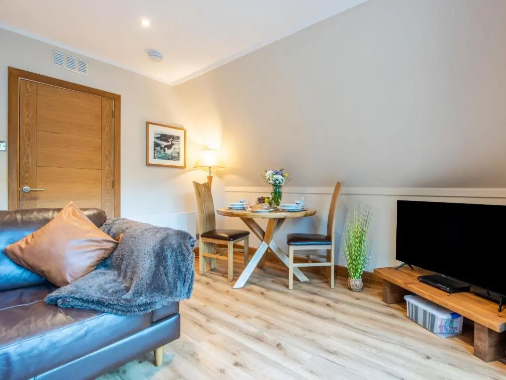 a living room with a couch and a table at Chalet Oystercatcher by Interhome in Spean Bridge
