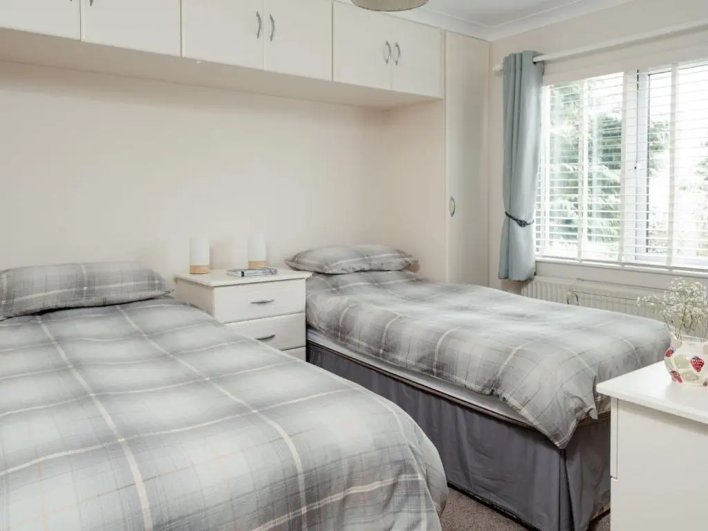 a bedroom with two beds and a window at Chalet Lodge 7 by Interhome in Boat of Garten