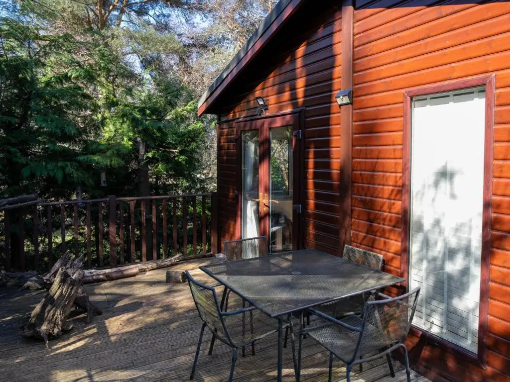 a patio with a table and chairs on a cabin at Chalet Lodge 7 by Interhome in Boat of Garten