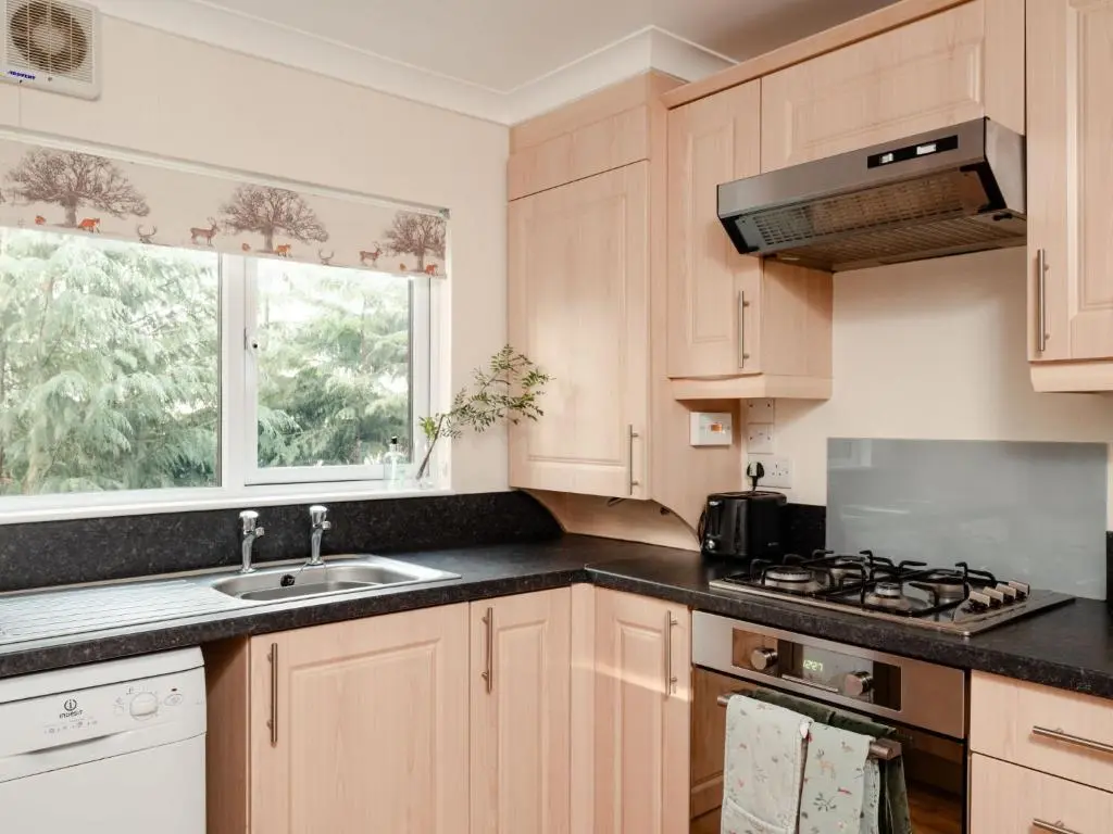a kitchen with a sink and a stove and a window at Chalet Lodge 7 by Interhome in Boat of Garten