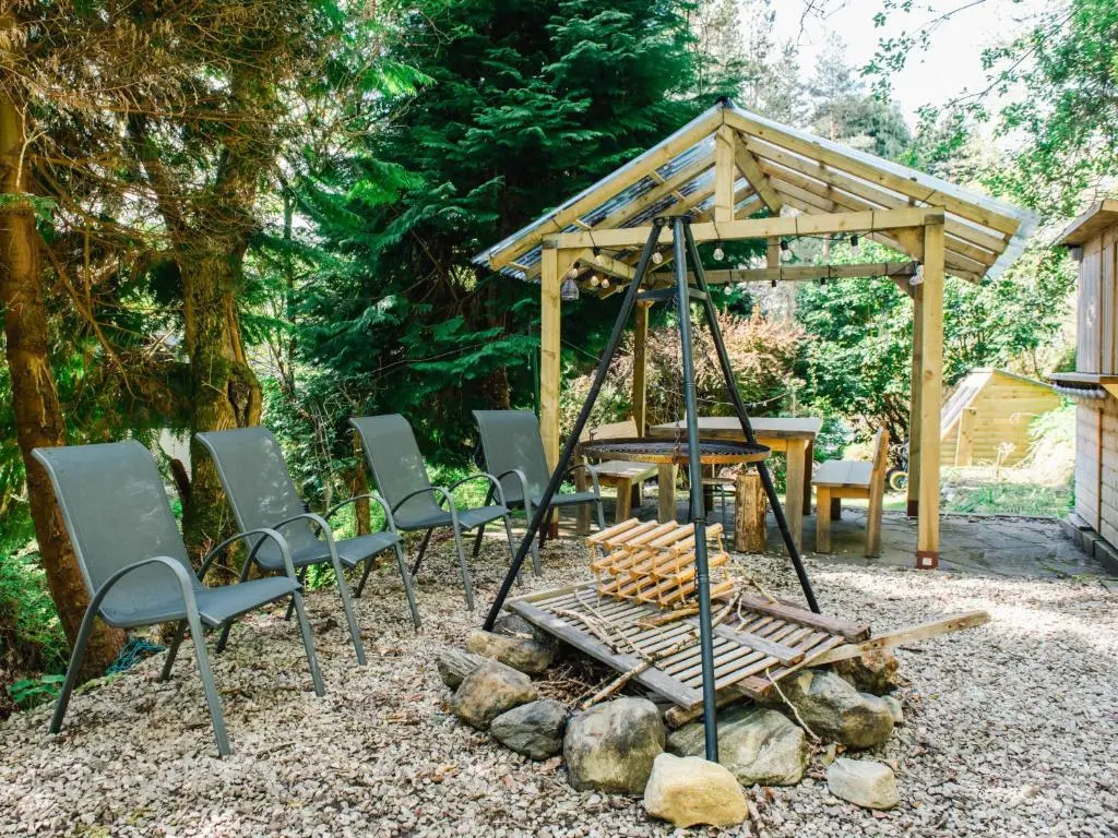 a group of chairs and a swing in a yard at Apartment Wayside Loft by Interhome in Drumnadrochit
