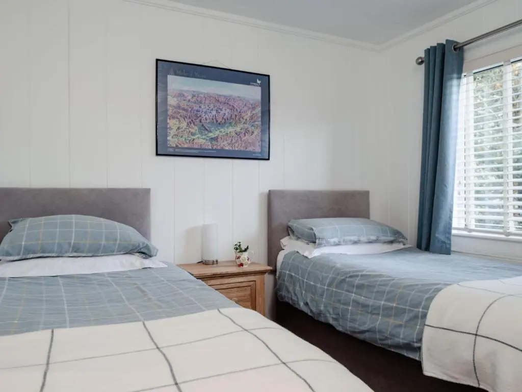 a bedroom with two beds next to a window at Chalet Lodge 2 by Interhome in Boat of Garten