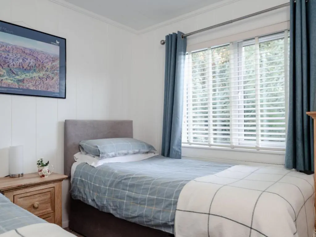 a bedroom with two beds and a window at Chalet Lodge 2 by Interhome in Boat of Garten