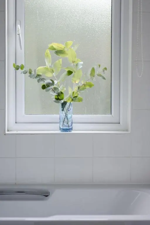 a vase of flowers sitting on a window sill at Chalet Lodge 2 by Interhome in Boat of Garten