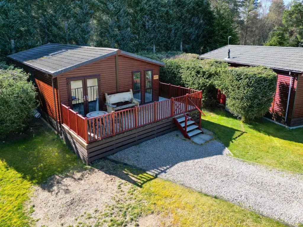 a small cabin with a porch and a deck at Chalet Lodge 2 by Interhome in Boat of Garten