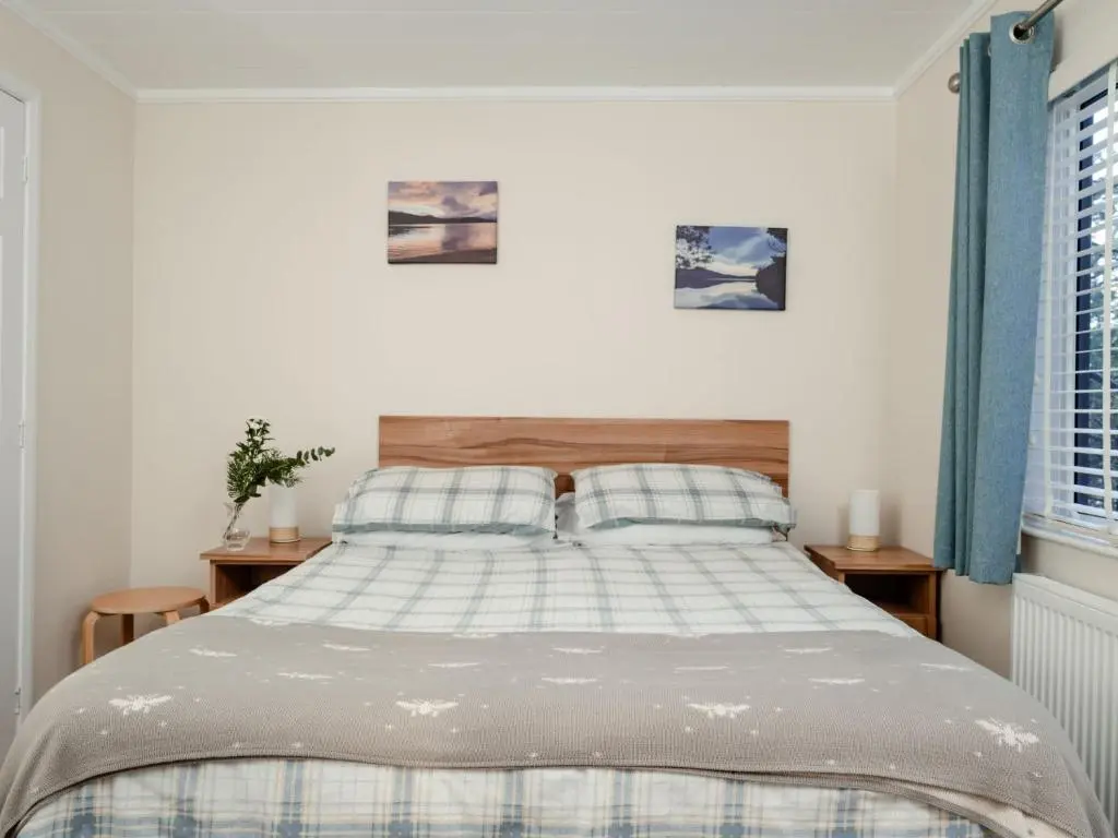 a bedroom with a bed with two pillows at Chalet Lodge 2 by Interhome in Boat of Garten