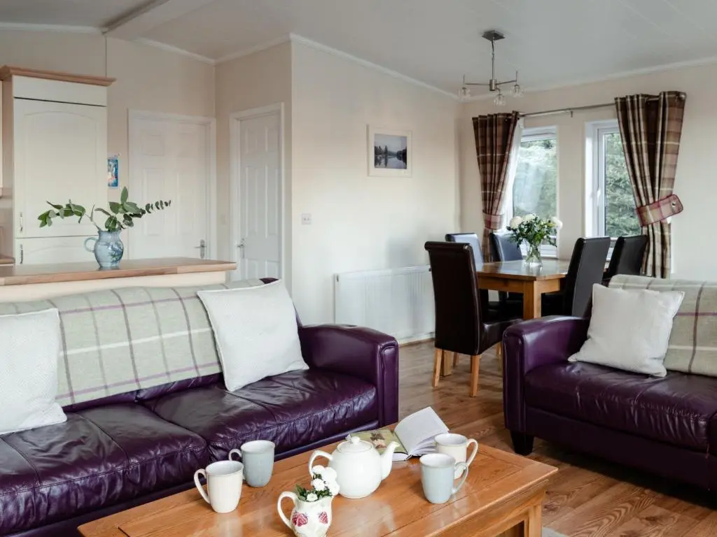 a living room with two purple couches and a table at Chalet Lodge 2 by Interhome in Boat of Garten