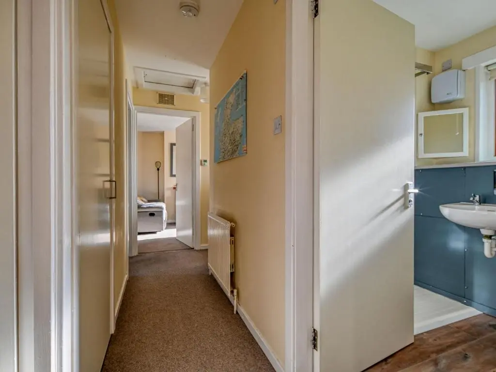 a hallway leading to a bathroom with a sink at Holiday Home Appletree by Interhome in Muir of Ord