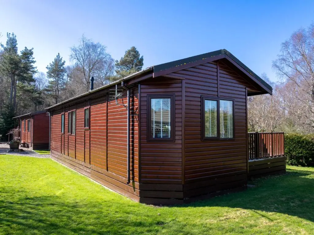 a small cabin in a field of grass at Chalet Lodge 4 by Interhome in Boat of Garten