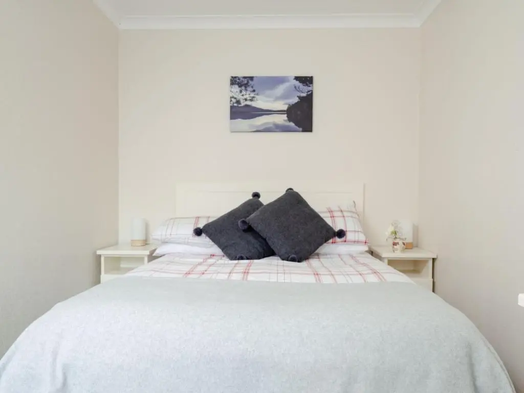 a white bed with two pillows on top of it at Chalet Lodge 4 by Interhome in Boat of Garten