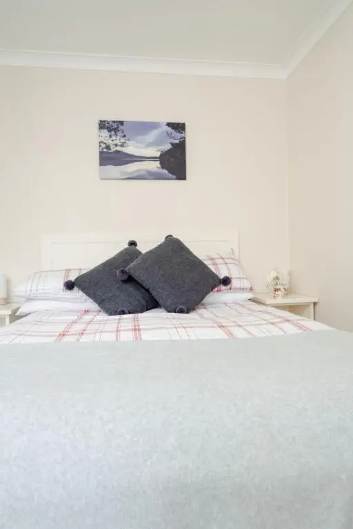 a white bed with two pillows on top of it at Chalet Lodge 4 by Interhome in Boat of Garten