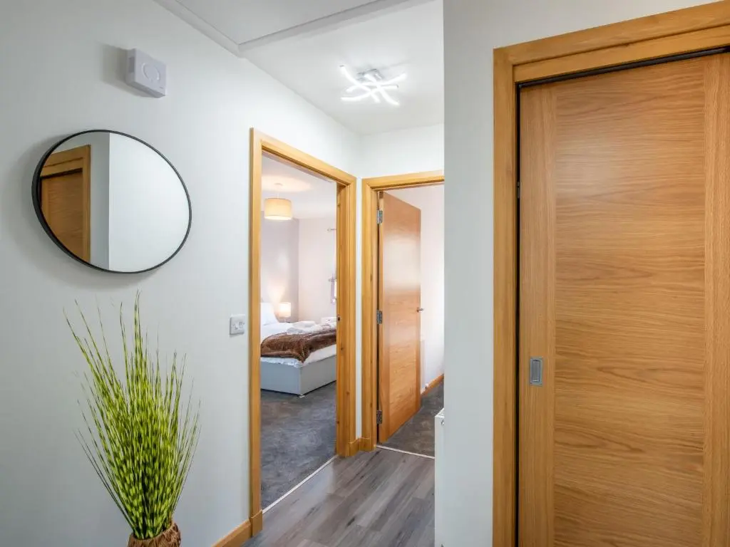 a hallway with a wooden door and a mirror at Apartment Shore Street by Interhome in Lossiemouth