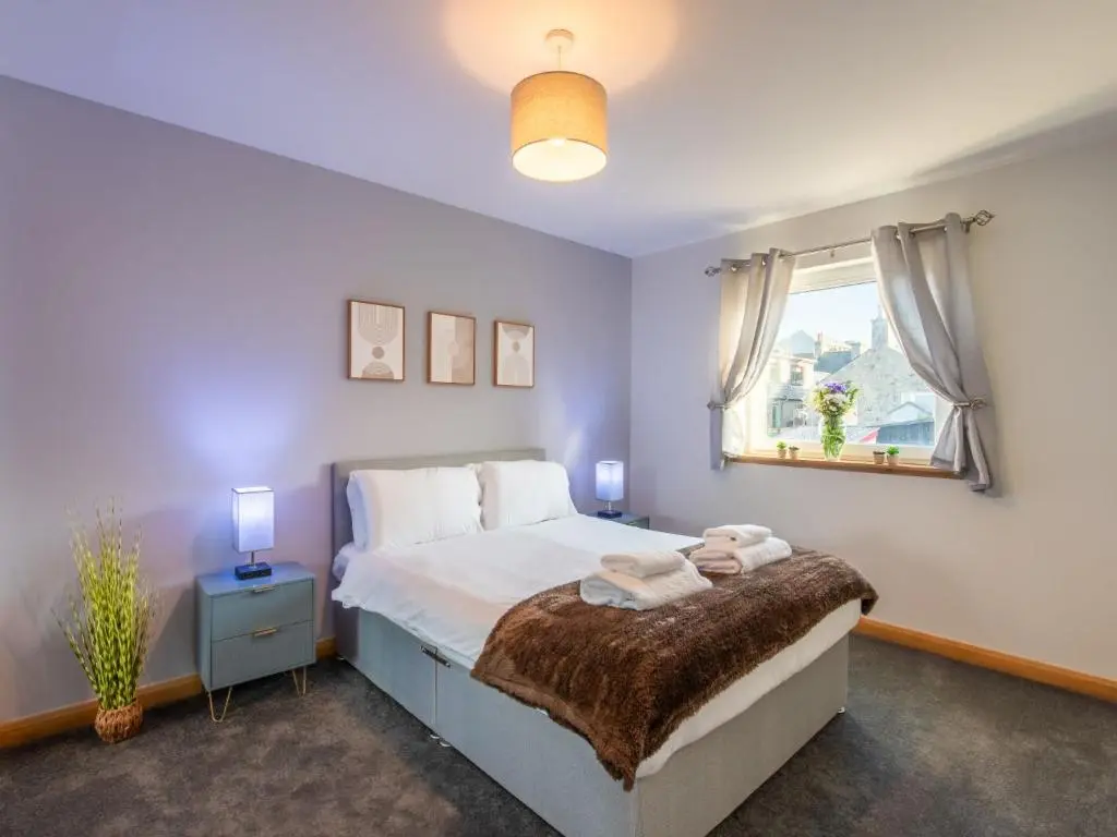 a bedroom with a large bed and a window at Apartment Shore Street by Interhome in Lossiemouth