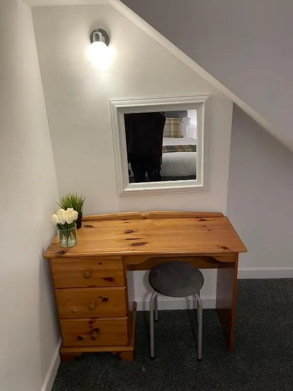 a desk with a mirror and a chair in a room at Tartan House in Inverness