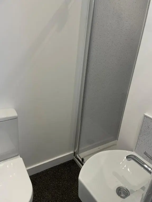 a bathroom with a white toilet and a sink at Tartan House in Inverness