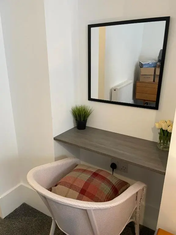 a mirror on a wall above a chair in a room at Tartan House in Inverness