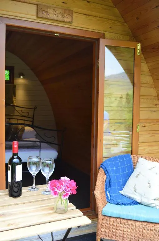 a table with wine glasses and flowers on a patio at Glenshee Glamping in Glenshee