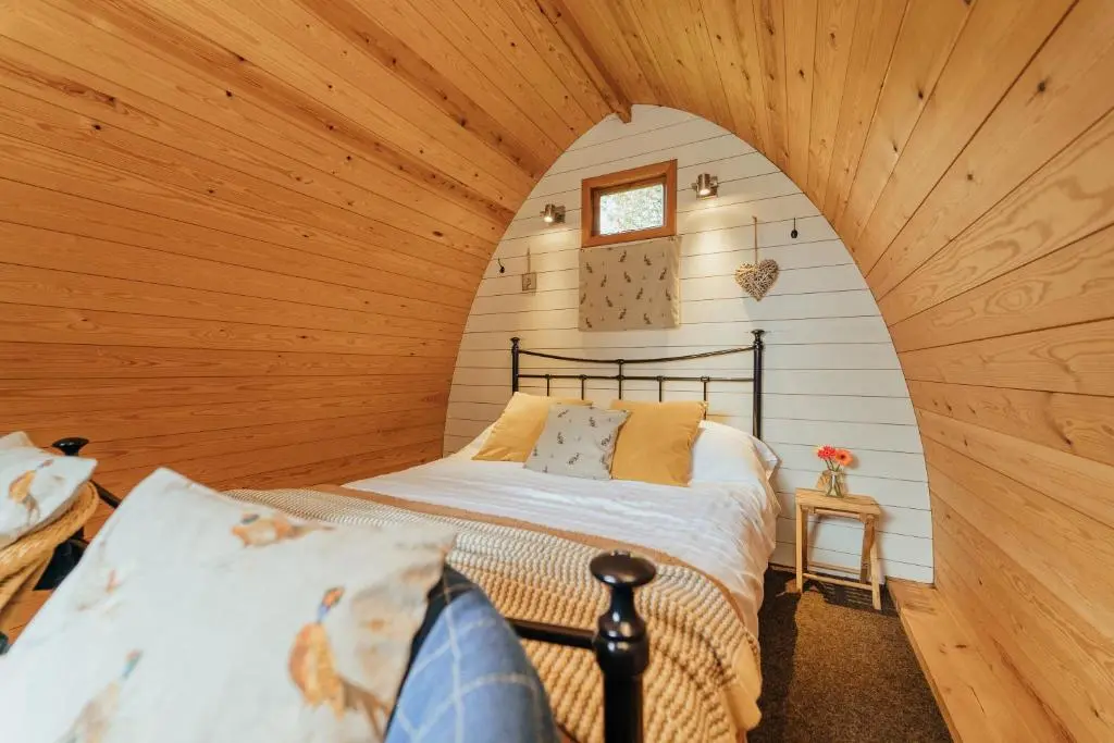 a bedroom with a bed in a wooden room at Glenshee Glamping in Glenshee