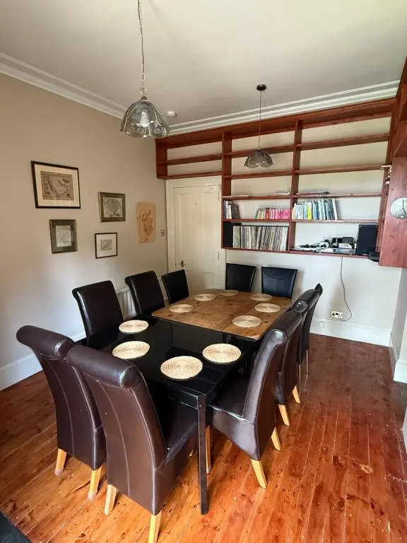 a dining room with a table and leather chairs at The Old Manse Oyne in Oyne