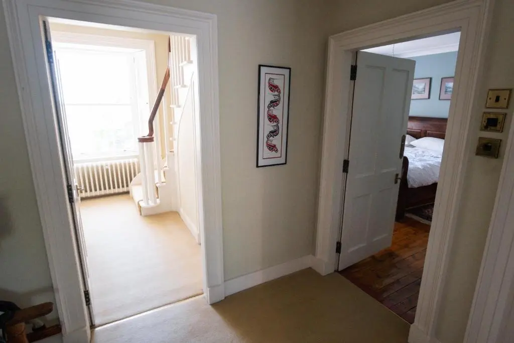 a hallway with a door leading to a bedroom at The Old Manse Oyne in Oyne