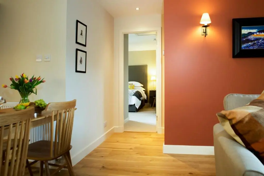 a living room with a red accent wall at Loch Cottage in Boat of Garten