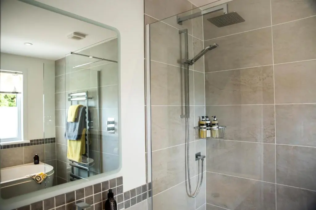 a bathroom with a shower with a glass door at Loch Cottage in Boat of Garten