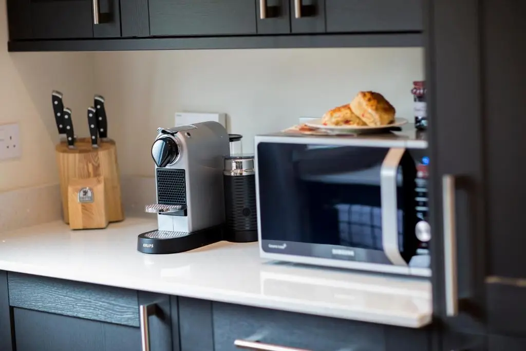 a microwave sitting on a counter with a plate of food at Loch Cottage in Boat of Garten