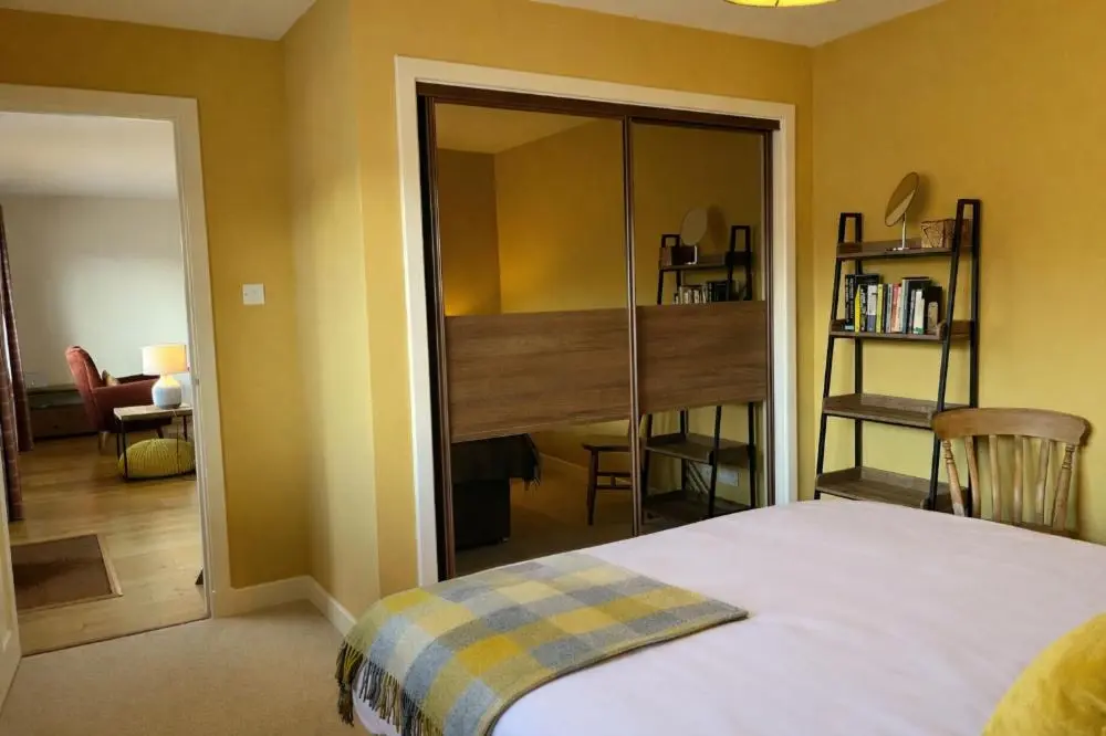 a bedroom with a bed and a sliding glass door at Loch Cottage in Boat of Garten