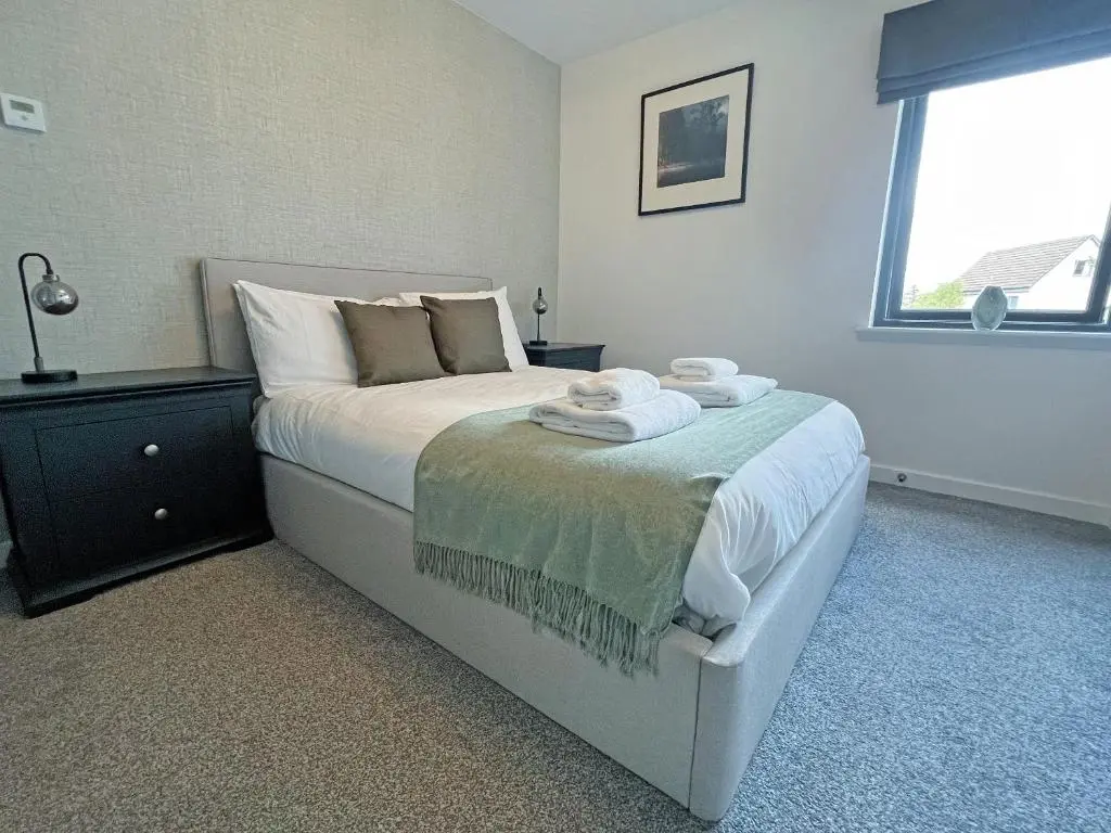 a bedroom with a bed with towels on it at The Peaks in Aviemore