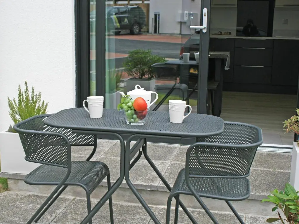a black table with chairs and a bowl of fruit on it at The Peaks in Aviemore