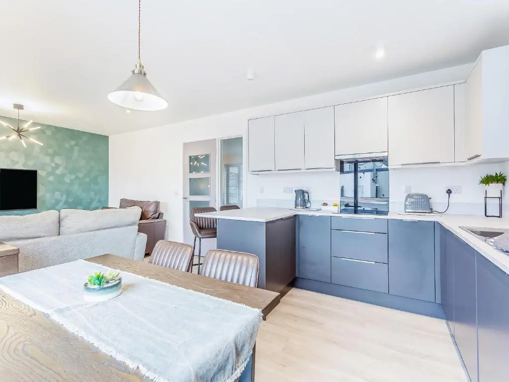 a kitchen and living room with a table and a couch at The Peaks in Aviemore