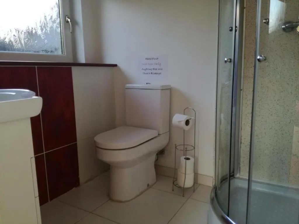 a bathroom with a toilet and a glass shower at Ardenlea House Hotel B&b in Dyce