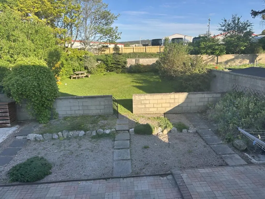 a backyard with a retaining wall and a garden at Dalwhinnie in Buckie