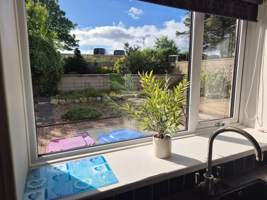 a kitchen window with a sink and a potted plant at Dalwhinnie in Buckie