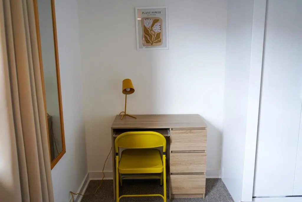 a yellow chair sitting next to a wooden desk at Rosehearty house - 3 bedroom in Rosehearty