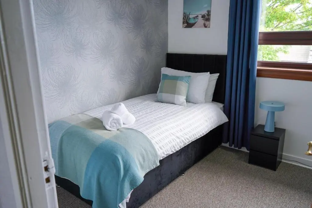 a bedroom with a bed with two towels on it at Rosehearty house - 3 bedroom in Rosehearty