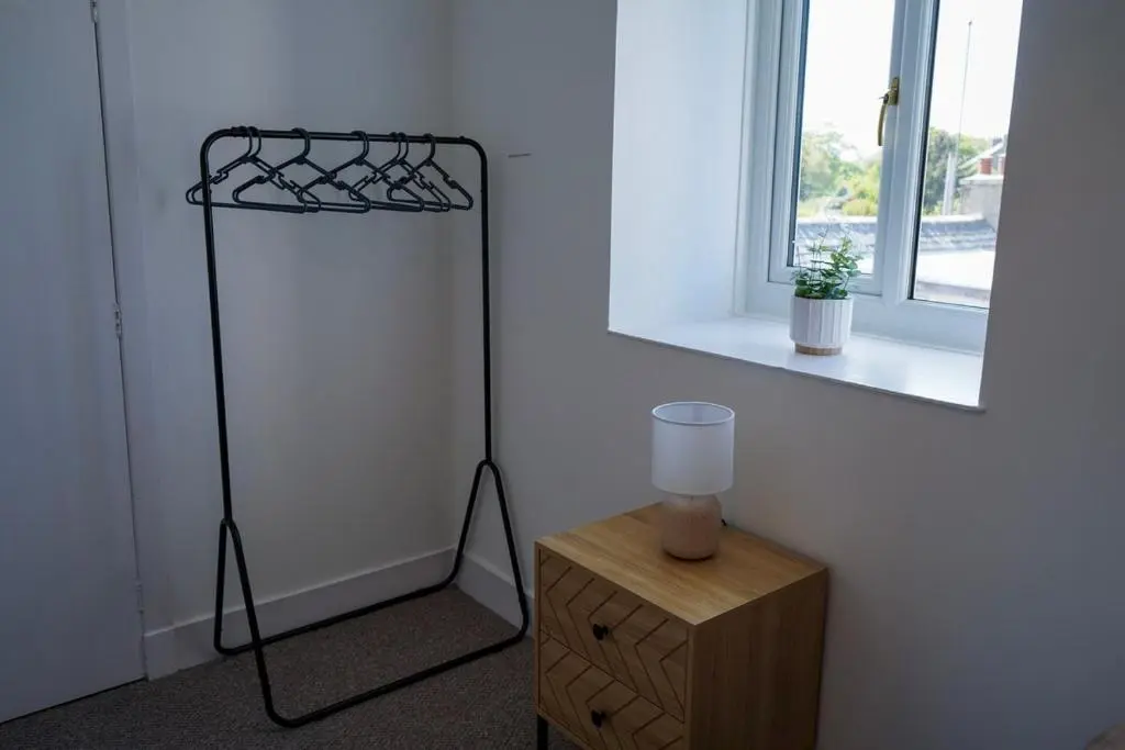 a room with a lamp on a stand next to a mirror at Park House - 3 bedroom in Portsoy