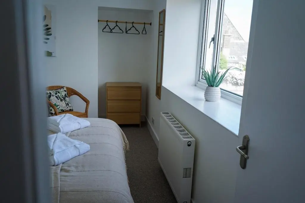 a bedroom with a radiator and a window at Park House - 3 bedroom in Portsoy