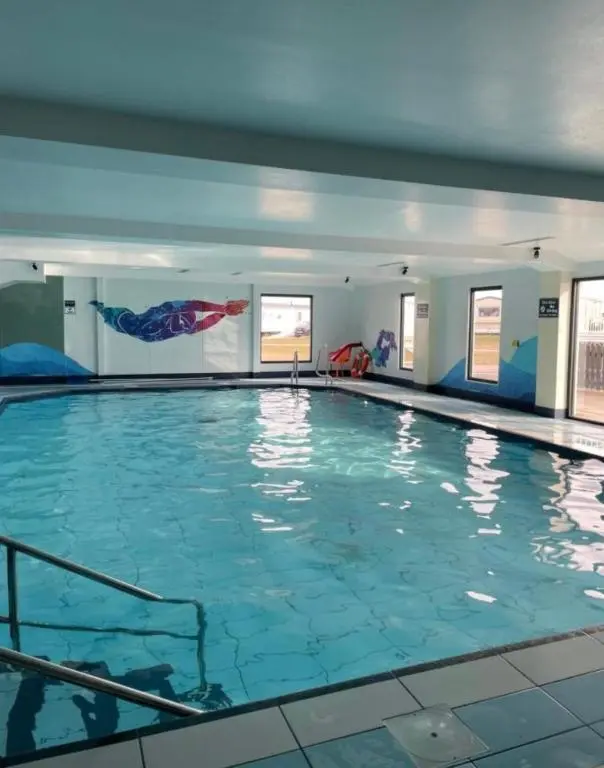 a swimming pool with blue water in a building at Biggerstaffs retreat in Lossiemouth