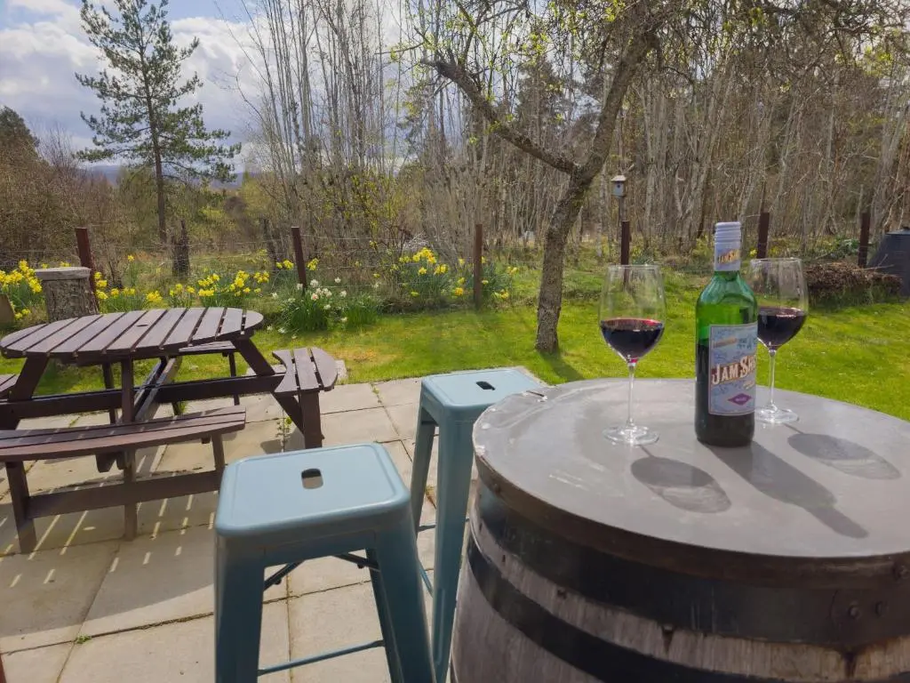 a table with a bottle of wine and two glasses at Killiechangie House in Newtonmore
