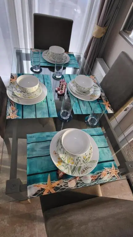 a glass table with plates on top of it at Northern Light Villa, forest, beach and bubbles in Burghead